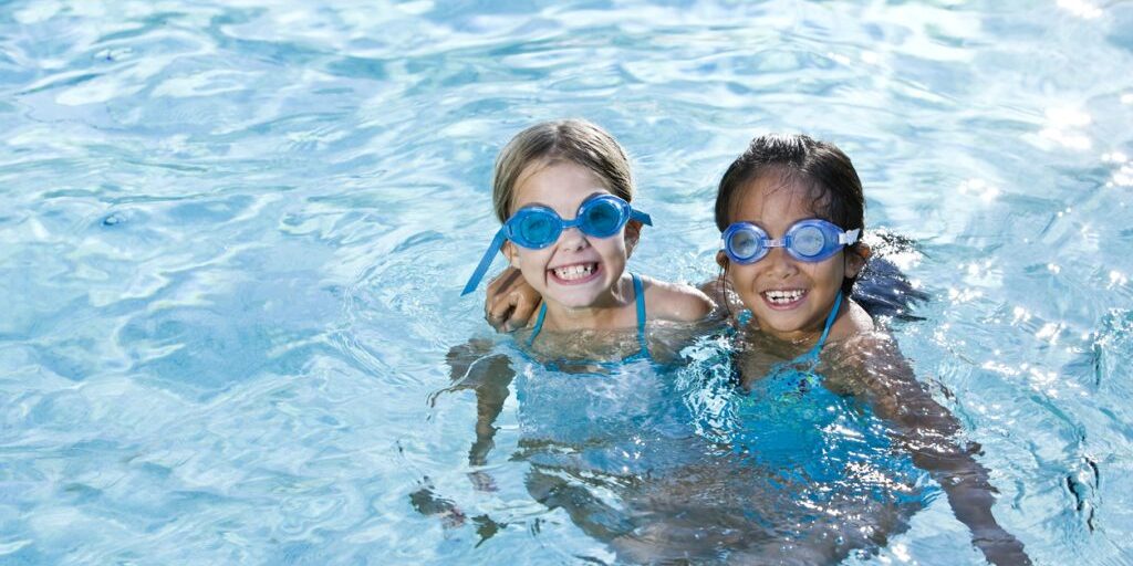 Best friends, girls smiling in swimming pool Best friends, girls smiling in swimming pool